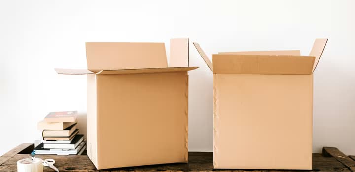 Photo of cardboard moving boxes and books on a table