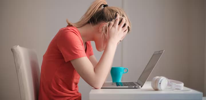 Woman in red t-shirt looking at her laptop